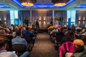 Zaal met mensen tijdens bijeenkomst Veilig Wonen Dag 2026 PKVW